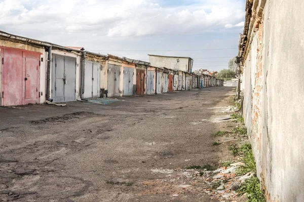 Garaj kooperatifi. Bir sıra araba garajı. Şehir mimarisi. Taşımacılık endüstrisi. Taş barakalar. Paslı demir kapı. Tuğla duvar. Mimaride perspektif. Terk edilmiş bir alan. Terk edilmiş sokak.