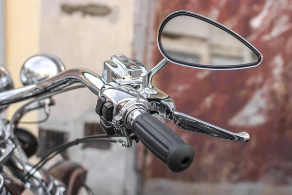 Classic chrome cruiser. Motorcycle handle. Front brake. The gas lever on the chopper. Speed dialing. Details of the motorcycle close-up. Part of the biker steering. Front turn signal.