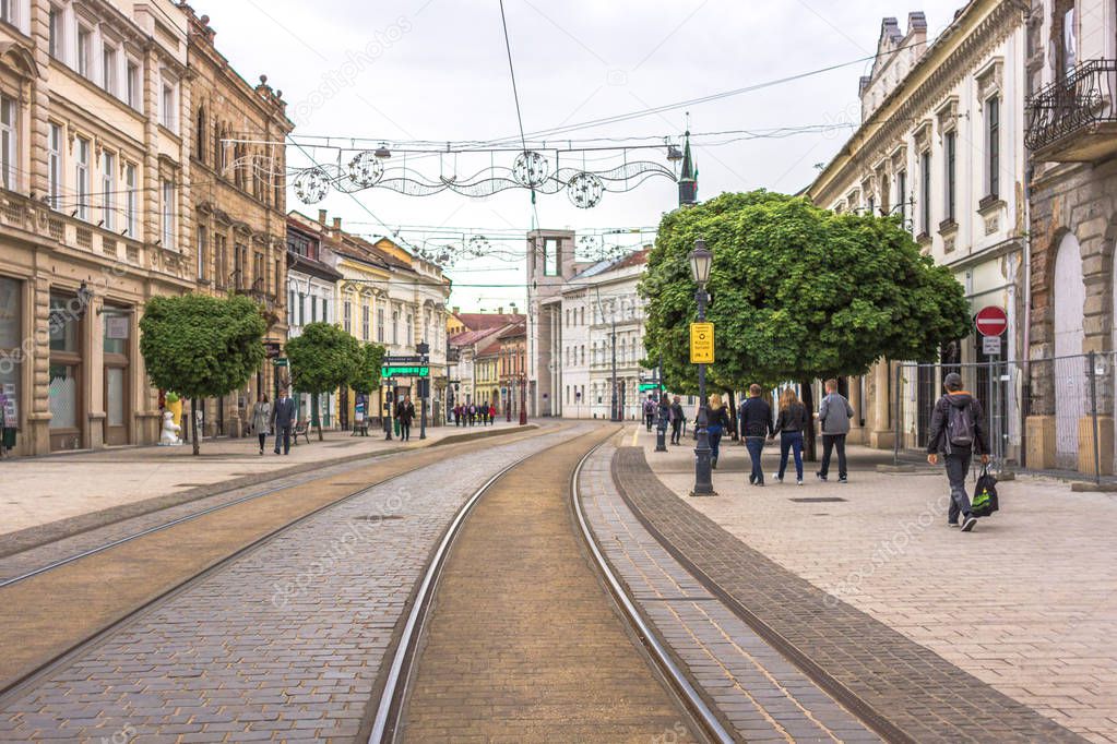 European city. Hungarian pavement. Street with tramways. Rails in the center of Miskolc. Cityscape with tramways. Urban transport. Urban railway. City center. The direction of the train.
