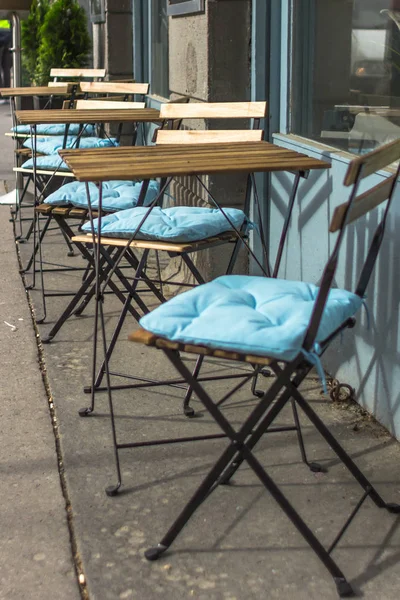 Summer terrace cafe. Empty tables and chairs. Garden furniture. Furniture cushions. Empty seats in the restaurant on the street. Place for morning coffee. Breakfast al fresco. Lunch time.