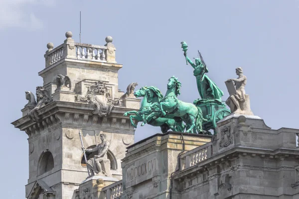 Parliament Building in Budapest. State institution in Hungary. Exterior of a historic building. Coats of arms on the wall. Statue with horses on the roof of the parliament. European architecture.