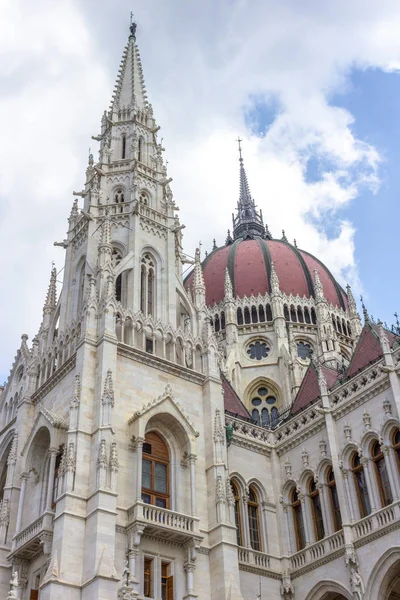 Parliament Building in Budapest. State institution in Hungary. Exterior of a historic building. Coats of arms on the wall. Statue with horses on the roof of the parliament. European architecture.