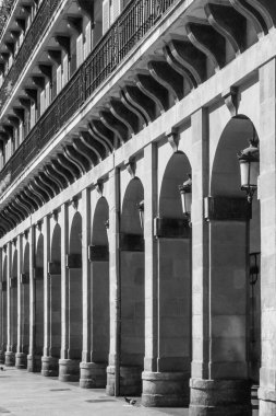 Kemerli kolonlar. Muazzam taş bir yapı. Mimaride katı çizgiler. Yüksek kemerler. Fotoğrafın kompozisyonundaki ritim. Tarihi bir binanın cephesi. Perspektif azalıyor.
