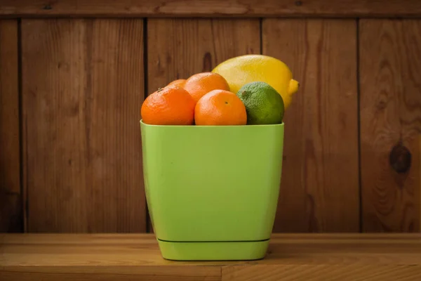 Citrus fruit. Tangerines, lemons and kiwi in a vase. Foods with vitamin C. Healthy food. Bright color of products. Still life of fruits on a detached background. Summer delicious diet.