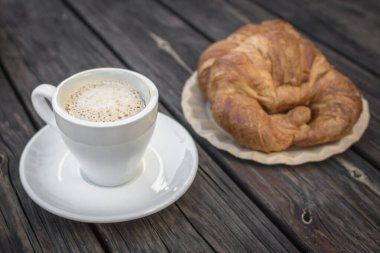 Taze fırın. Bir kahve dükkanı için samimi bir geçmiş. Sade kahve ve kruvasan. Fransız kahvaltısı. Tahta masa. Aromatik içki. Restoran teması. Sabah yemeği. Ofis yemeği..