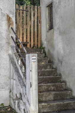 Dış merdiven. Tahta kapıya doğru adımlar atıyor. Özel bir evin verandası. Köydeki ev. Sokaktan giriş. Fakir bölge mimarisi. Tahta kapı. Avlunun kapısı..