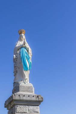 Gökyüzüne karşı Bakire Meryem figürü. Aziz Bernadette. Lourdes Bakiresi. Güç merkezi. Felç ve hastalıktan kurtulmak için hacca gitmek. Meryem Ana 'ya dua et..