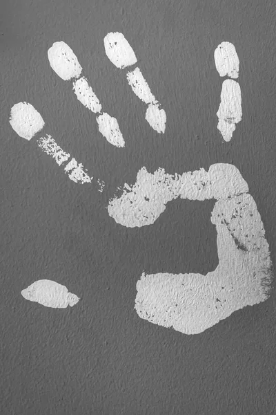 Part of the human body. Handprint with paint. Palm trail. Decor on the wall. Paint in the interior of the house. Five fingers. White paint on a gray wall. Leave a mark. Finger shape.