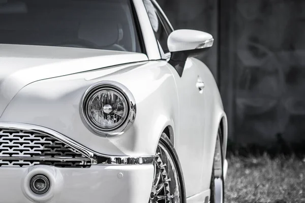 White car of the Pobeda brand. Executive class transport. Chrome details. Car service. Automotive industry. Nice sedan. Exhibition of retro cars. Custom vehicle presentation. Car shining in the sun.