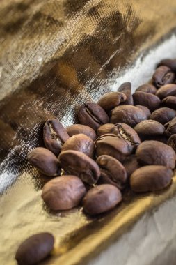 Aromatik sabah içkisi. Altın kaplama kahve çekirdekleri. Kahve molası. Kahve sever. Altın arka plan. Bir enerji ve yaşam kaynağı..