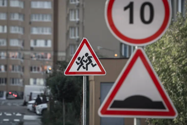 Warning road sign. Caution - children on the road. Attention of the driver behind the wheel. Traffic Laws. Speed Limit. Increased attention. Triangle sign by the road. White triangle in a red frame.