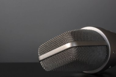 Karanlık bir arka planda diktafon. Ses kayıt stüdyosu. Ses ekipmanları. Filmleri, TV dizilerini ve reklamları puanlama ve seslendirme. Sesle çalışmak. Erkek ve kadın sesi.