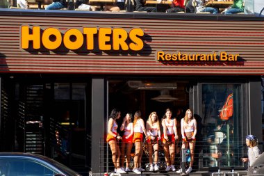 Montreal, Kanada - 27 Mayıs 2017: 2017 'de açılan Crescent Caddesi' ndeki restoranın vitrinindeki Hooters kızları. ABD merkezli ve pek çok ülkede konumları bulunan gelişigüzel dingilleme zincirinin bir parçası..