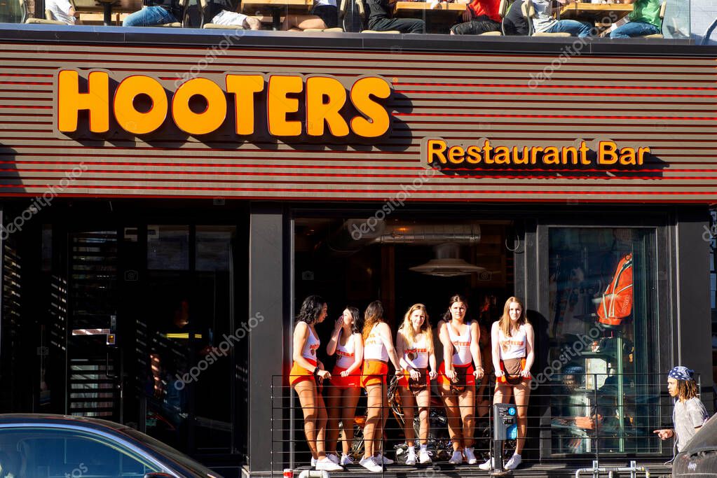 Montreal, Canada - May 27, 2017:  Hooters girls at the window of the restaurant on the trendy Crescent St that opened in March of 2017.  It is part of a US based casual dinging chain that has locations in several countries.
