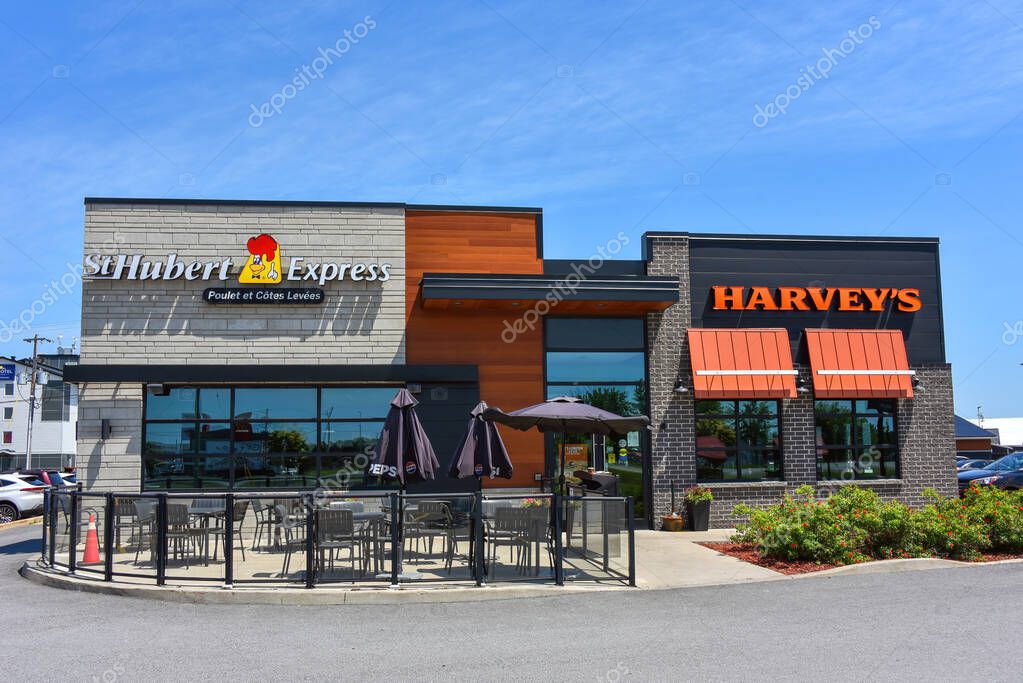 Casselman, Canada June 30, 2025 St-Hubert rotisserie chicken restaurant adjacent to a Harveys hamburger restaurant in eastern Ontario. Both companies are owned by the Recipe Unlimited Corporation.