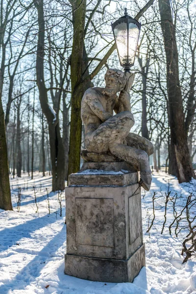 Łazienki Parkı Varşova'nda tarihi bir heykel. Arka planda kış manzarası görebilirsiniz