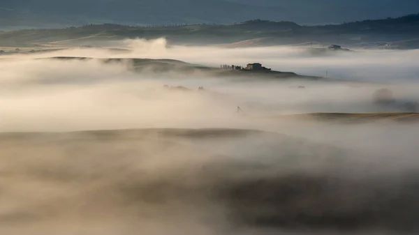 Misty valley in Tuscany. In the distance you can see villas on the hills