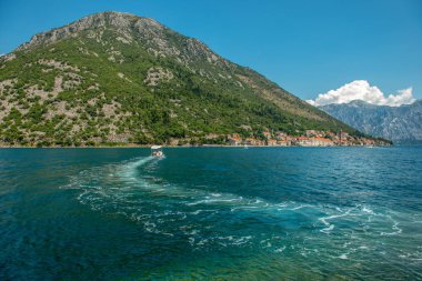 Uyan. Suda iz var. Karadağ 'ın Perast kentinin arka planında