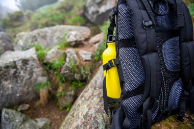 Sırt çantasında sarı bir su şişesi.