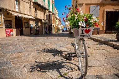 A charming street in Tropea, a bicycle with a sign is a meeting place for young people clipart