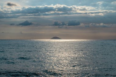 Güneş ışınları bulutları delip geçiyor. Uzakta aktif volkan Stromboli 'yi görebilirsiniz.
