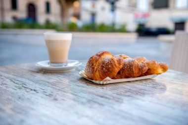 İtalya 'nın güneyinde tipik bir kahvaltı, kruvasan ve kahve - bayram gününe iyi bir başlangıç.