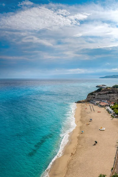 Piaggia della Rotonda, Tropea, Calabria, İtalya 'da konut binaları olan kayalık bir uçurumun yanındaki güzel bir sahil manzarası.