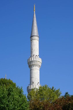 Image of architectural fragment of one minaret on blue sky background in Istanbul city, Turkey.