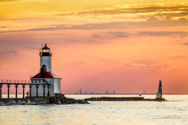 Michigan City, Indiana, ufukta Michigan Gölü güney ucunda arasında kontrast Chicago manzarası ile parlayan feneri geri batan güneşin ışıkları.