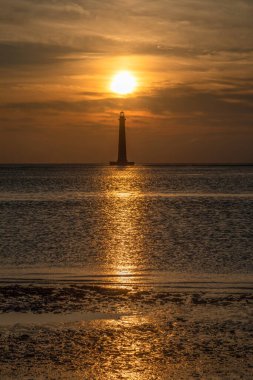 Tarihi Morris Adası Deniz Feneri, Güney Carolina, Charleston yakınlarındaki Atlantik Okyanusu 'ndan doğan sabah güneşiyle kaplandı. Folly Adası 'ndaki kumsalın fotoğrafını çektim..
