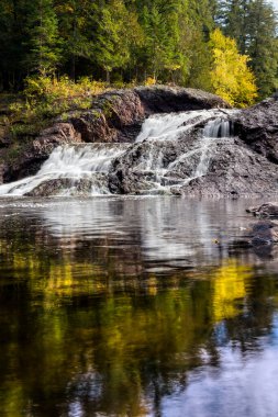 Whitewater, Michigan 'ın batı yarımadasındaki Black River' da sonbahar renklerinin sıçradığı bir şelale olan Büyük Holding Şelalesi 'ne dökülüyor..