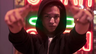 Genç adam gece portresi, neon ışıkla aydınlatılmış..