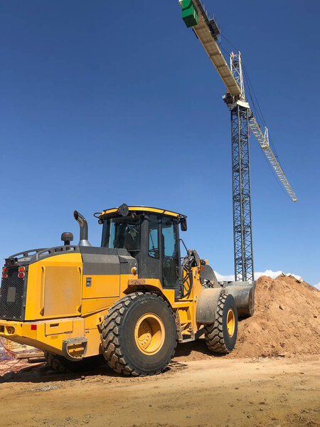 Строительная площадка с бульдозером и краном. Копирование пространства в голубом небе
.