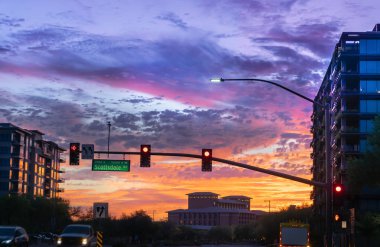 Dramatik günbatımı Kuzey Scottsdale, Arizona. Scottsdale rd ve Kierland Blvd. odak otomobil sürücüsü yol işaret üstünde-bir meşgul kavşak tarafından.
