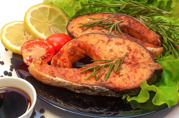 Bistecche di salmone alla griglia su un piatto con limone e pomodoro — Foto Stock