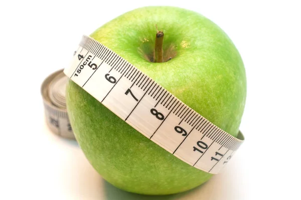 Manzana verde envuelta por cinta métrica aislada sobre fondo blanco — Foto de Stock