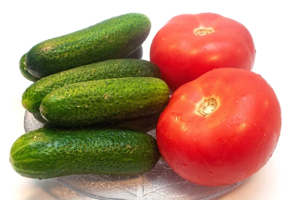 Gurken mit Tomaten in einem Teller auf weißem Hintergrund — Stockfoto