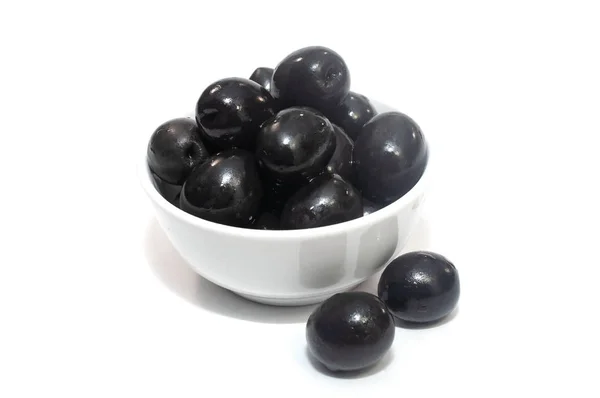 Черные оливки на изолированной тарелке — стоковое фото
