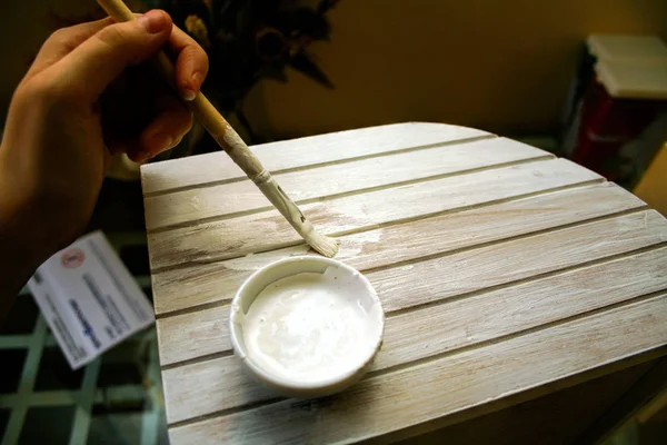 Pintura caixas de madeira em branco na mesa de vidro perto de pintar tigela e escova na mão — Fotografia de Stock