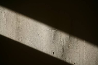 Bej beton duvarda güneş ışığı