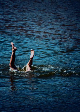 Okyanusa atlayan adam. Denize dalan adam. İnsan bacakları suyun üstünde. Sudan çıkan ayaklar 