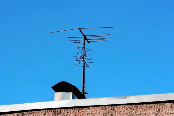 Old antenna on the roof of the house against the blue sky — Stock Photo, Image