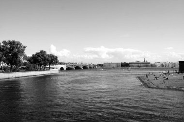 Siyah ve beyaz arka planda şehir manzarası ile Nehir. Neva nehri, Peter ve Paul Kalesi plajı sağda güneşlenen insanlar, solda ağaçlarla dolgu görünümü