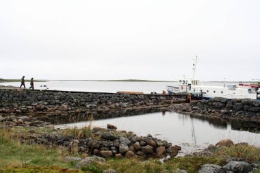 Solovetsky Adaları, Rusya - 18 Haziran 2009: Bir grup turist, takımadaların en önemli arkeolojik alanı olan Bolşoy Zayatsky Adası 'ndaki antik labirenti ziyaret etmek üzere tekneye bindiler.