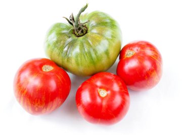 Büyük yeşil ve beyaz bir arka plan üzerinde birkaç olgun kırmızı domates