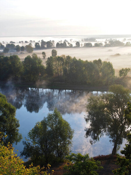 Top view of Desna River and meadows in fog in the early morning