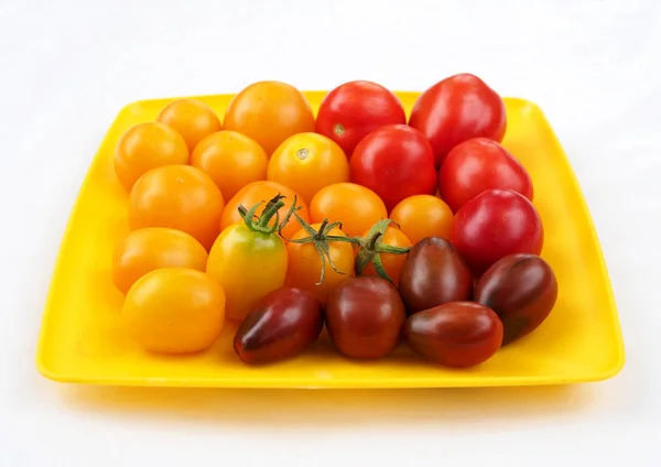 Viele Tomaten Verschiedener Sorten Auf Einem Gelben Teller — Stockfoto