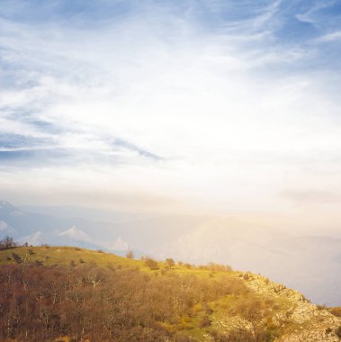 Dağ yamacı, güneşin bulutların üstünde
