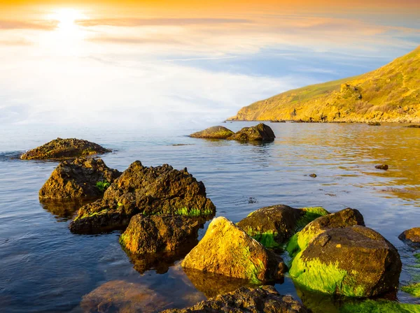 安静的海湾与石头在水中在日落 — 图库照片