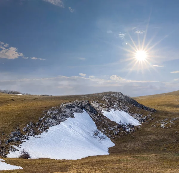 乾いた草と輝き太陽の下で雪の冬の丘 — ストック写真